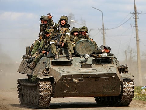Service members of pro-Russian troops are seen atop an armoured vehicle during Ukraine-Russia conflict in the southern port city of Mariupol, Ukraine April 21, 2022.