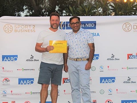 Neil Maidment (left), winner of Division 3 in the last Emirates NBD Race to Malaysia Qualifier receiving his prize from Saurabh Lodha, from Emirates NBD, at Montgomerie Golf Club, Dubai.