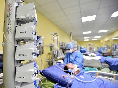 File photo: Member of the medical staff in protective suit treats a patient suffering from COVID-19 in an intensive care unit at the San Raffaele hospital in Milan, Italy.