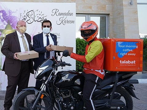 Dr J.M. Gauer (left) and Dr Raza Siddiqui presenting an iftar pack to a delivery rider