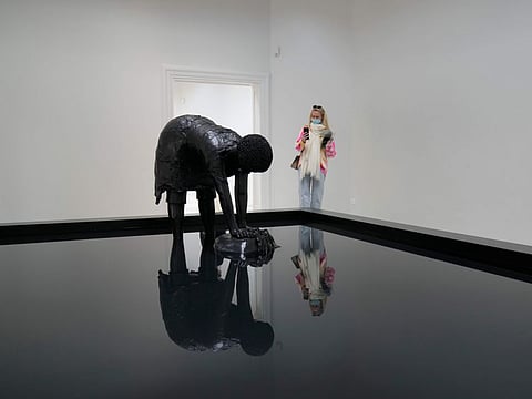 A visitor stands next to “Last Garment” sculpture part of the “Sovereignty” installation by artist Simone Leigh, at the United States' pavilion during the 59th Biennale of Arts exhibition in Venice, Italy, Tuesday, April 19.