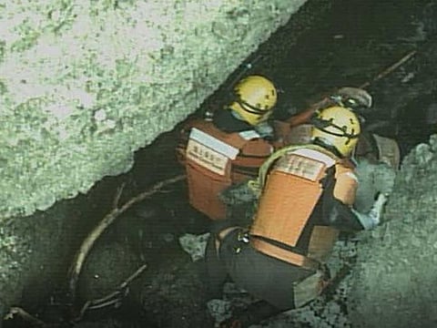 This handout picture taken and released on April 24, 2022 by the 1st Regional Coast Guard Headquarters shows personnel conducting a search and rescue operation for those on board the missing tourist boat Kazu I at a rocky coastal area of Hokkaido's Shiretoko peninsula.