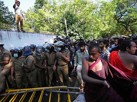 Sri Lankan university students shout slogans after pushing down barricades as police watch during a protest over the country’s worst economic crisis in decades outside the residence of prime minister Mahinda Rajapaksa in Colombo, Sri Lanka, Sunday, April 24, 2022.