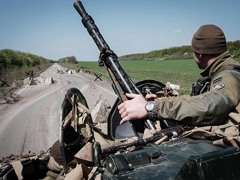 A Ukrainian soldier sits on a Armoured personnel carrier (APC) driving on a road near Slovyansk, eastern Ukraine, on April 26, 2022.