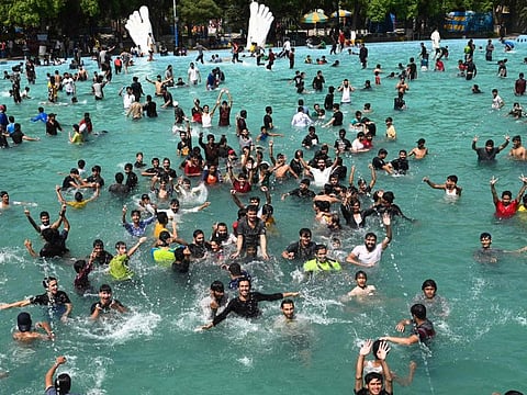 People cool off at a swimming pool during a hot summer day in Lahore on April 28, 2022.