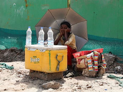 A girl selling water on a hot summer day, in New Delhi, India