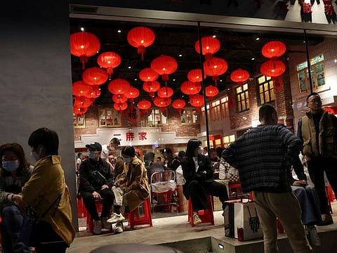 Customers wait in front of a restaurant in Beijing on April 15, 2022.