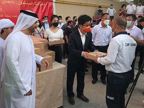 Chinese consul-general Li Xuhang (centre) and Dr Omar Al Muthanna (left) from CDA distributing iftar
