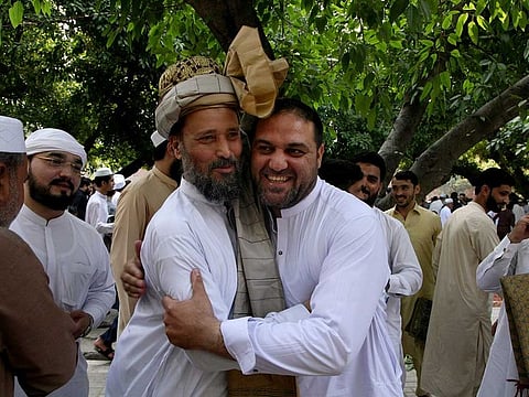 Muslims share Eid greetings after offering the Eid Al Fitr prayer, marking the end of Ramadan, in Peshawar, Pakistan, Monday, May 2, 2022.