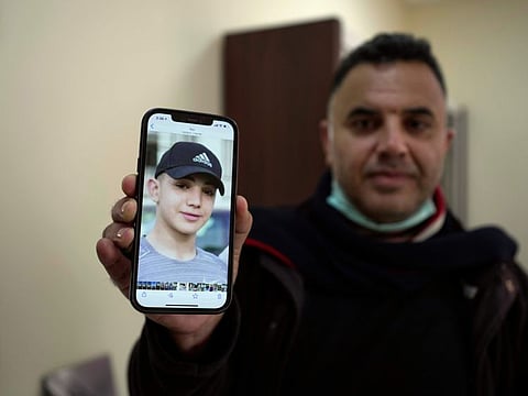 Muamar Nakhleh, father of Amal Nakhleh, a Palestinian teen with a rare neuromuscular disorder, who has been held without charge for a year in what Israel refers to as "administrative detention," shows his photo at his office, in the West Bank city of Ramallah.