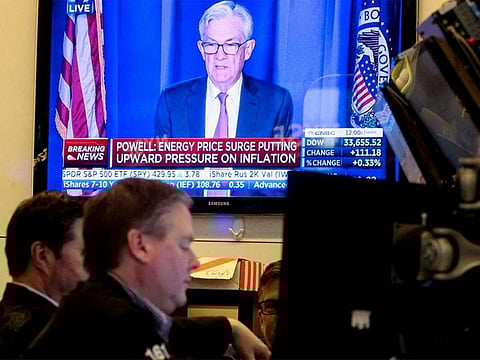 Traders work as Federal Reserve Chair Jerome Powell is seen delivering remarks on a screen at the New York Stock Exchange (NYSE) in New York City