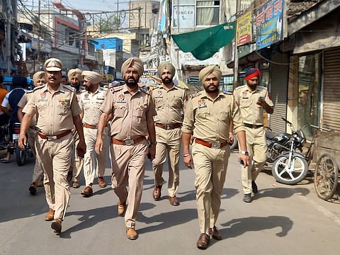 Police personnel patrol the streets after clashes that took place near Kali Devi Temple in Patiala, Punjab, India