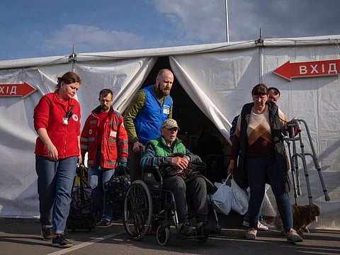 Volunteers assist a man after his arrival from the Ukrainian city of Mariupol at a center for displaced people in Zaporizhzhia, Ukraine, May 3, 2022.