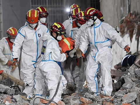 In this photo released by Xinhua News Agency, rescue workers evacuate the 10th survivor pulled alive after being trapped 132 hours from the debris of a self-built residential structure that collapsed in Changsha in central China's Hunan Province on Thursday May 5, 2022.