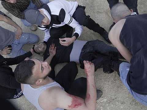 Palestinians help a wounded man during clashes with Israeli soldiers in the West Bank village of Silat Al Harithiya, near Jenin, on May 7, 2022.
