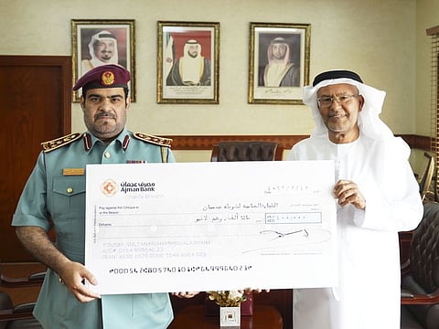 Yousef Sultan Al Ajmani (right) and Brigadier General Khalid Mohammad Al Nuaimi with the donation cheque