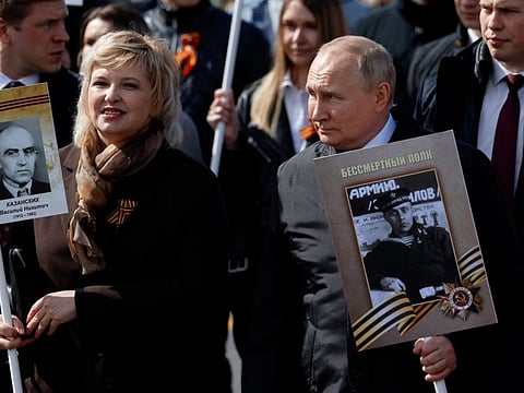 Russian President Vladimir Putin takes part in the Immortal Regiment march on Victory Day, which marks the 77th anniversary of the victory over Nazi Germany in World War Two, in central Moscow, Russia May 9, 2022.