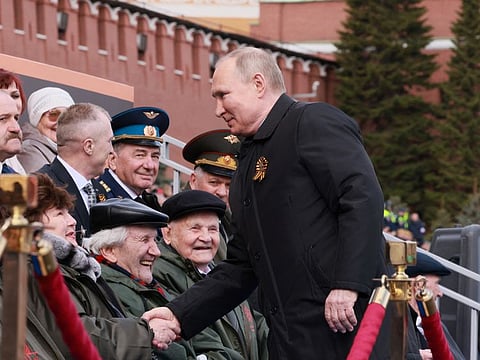 Russian President Vladimir Putin shakes hands with spectators before a military parade on Victory Day, which marks the 77th anniversary of the victory over Nazi Germany in World War Two, in Red Square in central Moscow, Russia May 9, 2022.