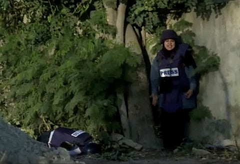 A colleague reacts next to the dead body of Al Jazeera journalist Shireen Abu Akleh, who was killed by Israeli army gunfire during an Israeli raid, according to the news channel, in Jenin in the Israeli-occupied West Bank, May 11, 2022, in this still image from a handout video.