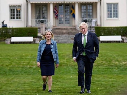 British Prime Minister Boris Johnson and Sweden's Prime Minister Magdalena Andersson take a walk around the gardens, in Harpsund, the country retreat of Swedish prime ministers, on May 11, 2022. Johnson is visiting Sweden and Finland ahead of their decision on whether to apply for Nato membership.