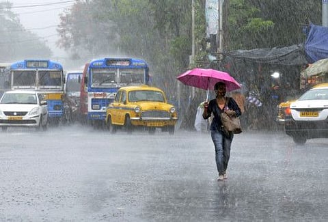 A woman walks during heavy rainfall in the wake of the storm 'Asani' in Kolkata.