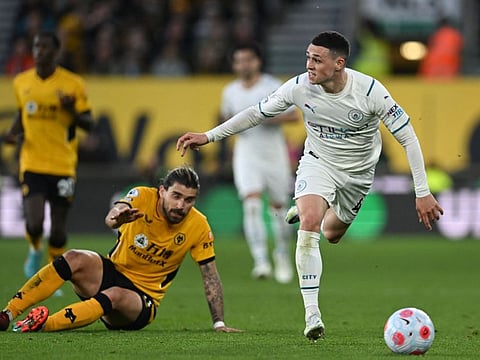 Manchester City's English midfielder Phil Foden (right) runs past Wolverhampton Wanderers' Portuguese midfielder Ruben Neves during the English Premier League match at the Molineux stadium in Wolverhampton, central England.