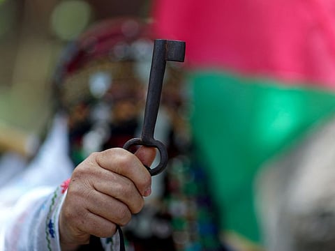 A Palestinian woman holds up a key symbolising their demand to return to homes they fled or were expelled from in the war that led to the founding of Israel in 1948, during a rally marking the 74th anniversary of Nakba, or catastrophe, in Gaza City May 15, 2022.