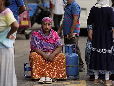An elderly woman waits outside a police station as she demands cooking gas in Colombo on May 14.