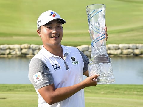 K.H. Lee of South Korea holds up the 2022 AT&T Byron Nelson trophy in McKinney, Texas, on Sunday. Lee finished 26 strokes under par to win the tournament.