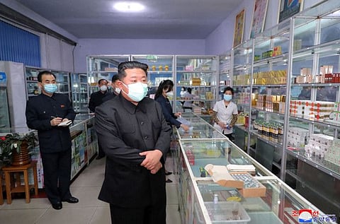 This picture taken on May 15, 2022 and released from North Korea's official Korean Central News Agency (KCNA) on May 16 shows North Korean leader Kim Jong Un (C) inspecting a pharmacy in Pyongyang.