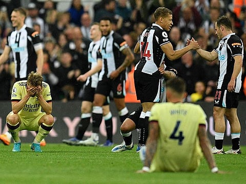 Arsenal's Norwegian midfielder Martin Odegaard (L) and Arsenal's English defender Ben White react after the English Premier League football match between Newcastle United and Arsenal at St James' Park in Newcastle-upon-Tyne, north east England on May 16, 2022.