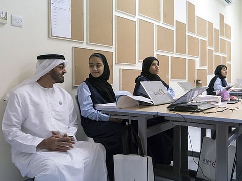 His Highness Sheikh Mohamed bin Zayed Al Nahyan with students at Al Asayel Primary School, earlier.