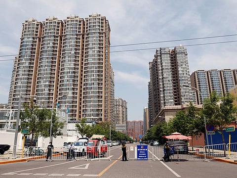 Security personnel keep watch at the entrance to an area under lockdown in Beijing on May 17, 2022.