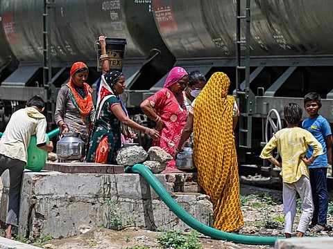 Women filling their pitchers with water supplied by a special train on a hot summer day in Pali.
