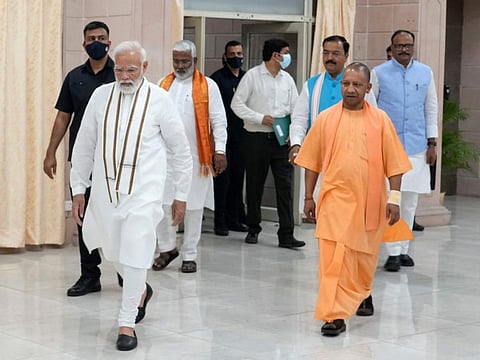 Indian Prime Minister Narendra Modi, left, with Uttar Pradesh Chief Minister Yogi Adityanath, arrive for a meeting with state ministers, in Lucknow on May 16, 2022.