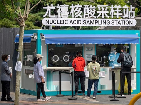 A worker administers a COVID-19 test at a site in Beijing, on May 19, 2022.