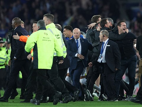 Everton manager Frank Lampard (right) celebrates avoiding relegation from the Premier League after the match as Crystal Palace manager Patrick Vieira (left) is escorted off the pitch by security.