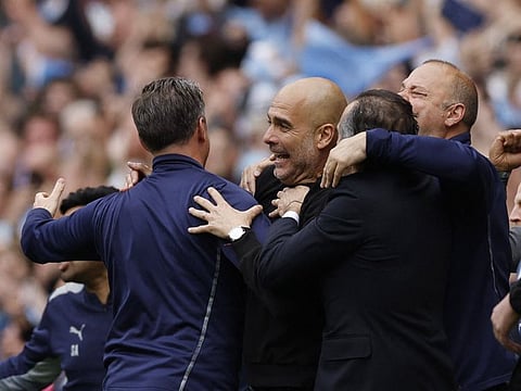 Manchester City manager Pep Guardiola celebrates after winning the Premier League.