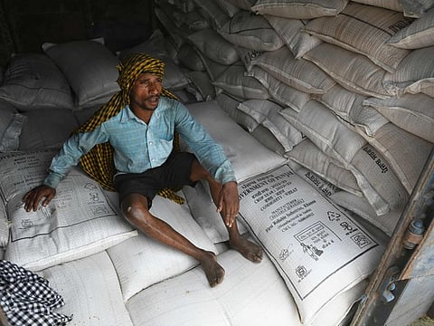 A worker takes a break from loading sacks of wheat on a freight train at Chawa Pail railway station in Khanna, Punjab state, on May 19, 2022. - India, the world's second-largest producer of wheat, on May 14 announced it would ban exports without special authorisation from the government in the face of falling production caused primarily by an extreme heatwave.