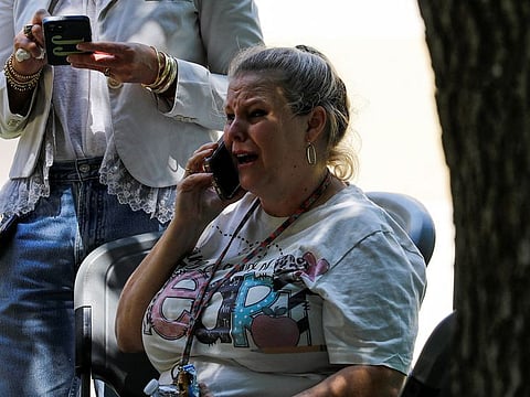 A woman reacts while talking on the phone outside the Ssgt Willie de Leon Civic Center, where students had been transported from Robb Elementary School to be picked up after a shooting, in Uvalde, Texas, U.S. May 24, 2022.