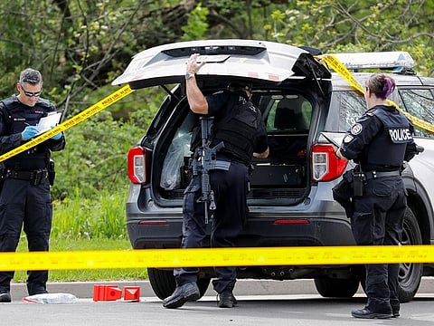 Police officers work at the scene where police shot and killed a suspect who was walking down a city street carrying a gun, as four nearby schools were placed on lockdown, in Toronto, Ontario, Canada, May 26, 2022.