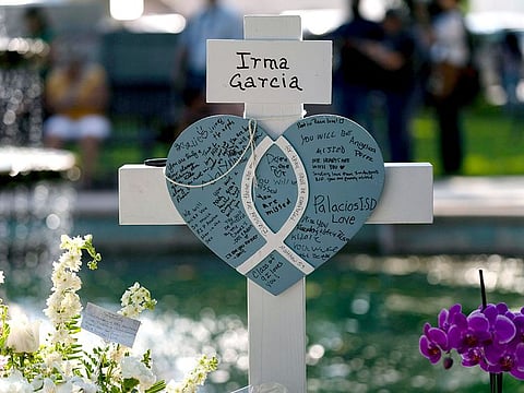 Messages are written on a cross honoring Irma Garcia, a teacher who was killed in this week's elementary school shooting, in Uvalde, Texas, Thursday, May 26, 2022.