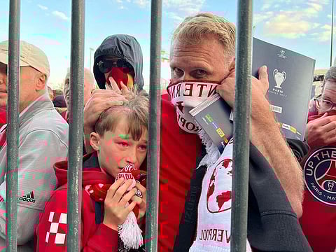 Liverpool fans react as they queue to access Stade de France before Champions League Final.
