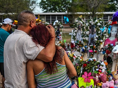 People pay tribute and mourn at a makeshift memorial for the victims of the Robb Elementary School shooting in Uvalde, Texas, May 31, 2022.