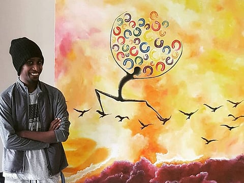 Artist Brook Yeshtila with one of his works.
