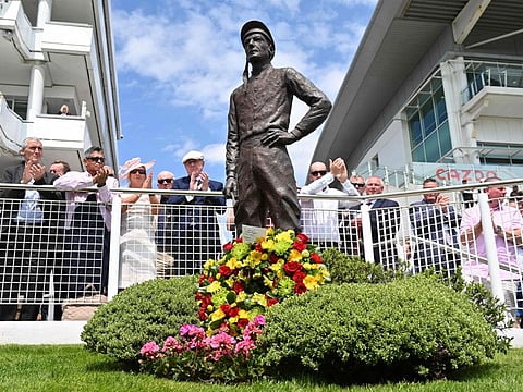 A wreath laid by Jockey Ryan Moore is seen at the statue of former jockey Lester Piggott, who died earlier in the week, on the first day of the Epsom Derby Festival in Epsom on Friday.