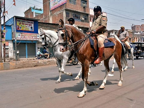 Police officials talk to religious leaders after violence erupted between two groups at the Parade Chauraha area, in Kanpur on Saturday.