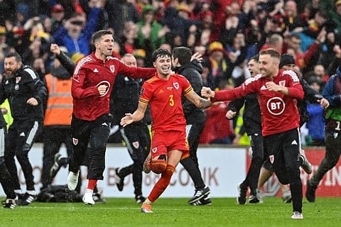 Wales' defender Neco Williams (centre) celebrates with teammates after winning the FIFA World Cup 2022 play-off final qualifier match against Ukraine at the Cardiff City Stadium in Cardiff, south Wales.