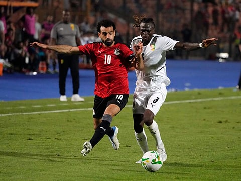 Egypt's Mohamed Salah (left) fights for the ball with Guinea's Issiaga Sylla during their Group D 2023 Cup of Nations (AFCON) qualifier at Cairo International stadium in Cairo, Egypt.