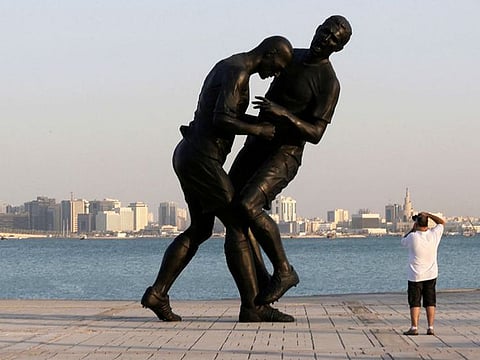 A man takes pictures of a bronze sculpture titled 'Coup de Tete' by Algerian-born French artist Adel Abdessemed during its installation on the Corniche in Doha. The sculpture, which was bought by the Qatar Museums Authority, was removed on October 28, 2013 after fears it promotes violence. The art work portrays French footballer Zinedine Zidane headbutting Italian player Marco Materazzi during the 2006 World Cup.